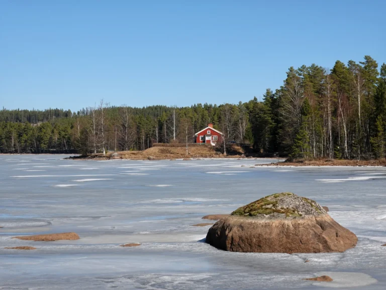Bevroren meer met een traditioneel rood Zweeds huisje op de achtergrond in Värmland