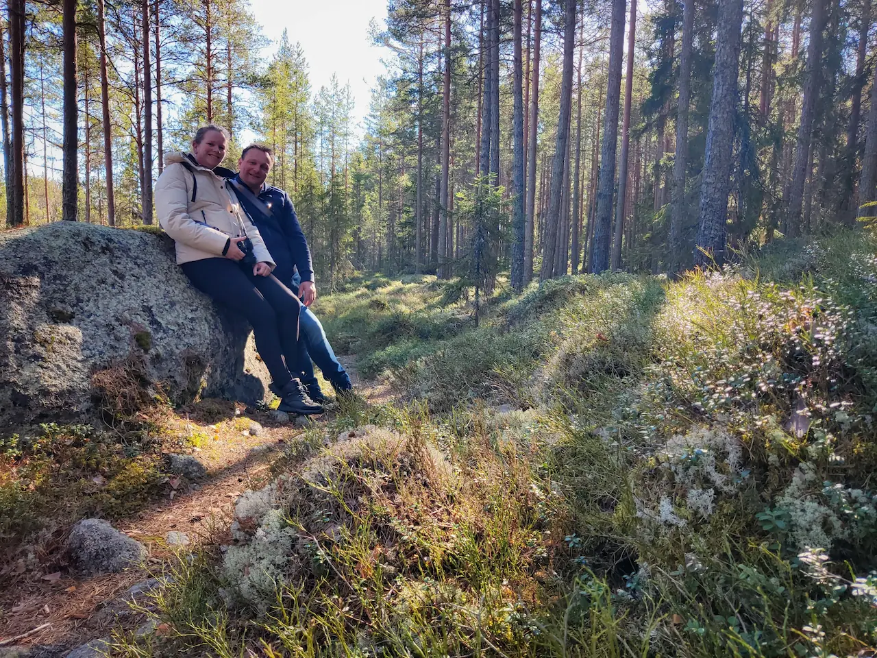 Erik en Patricia rusten uit bij een grote steen tijdens een wandeling door de natuur van Värmland