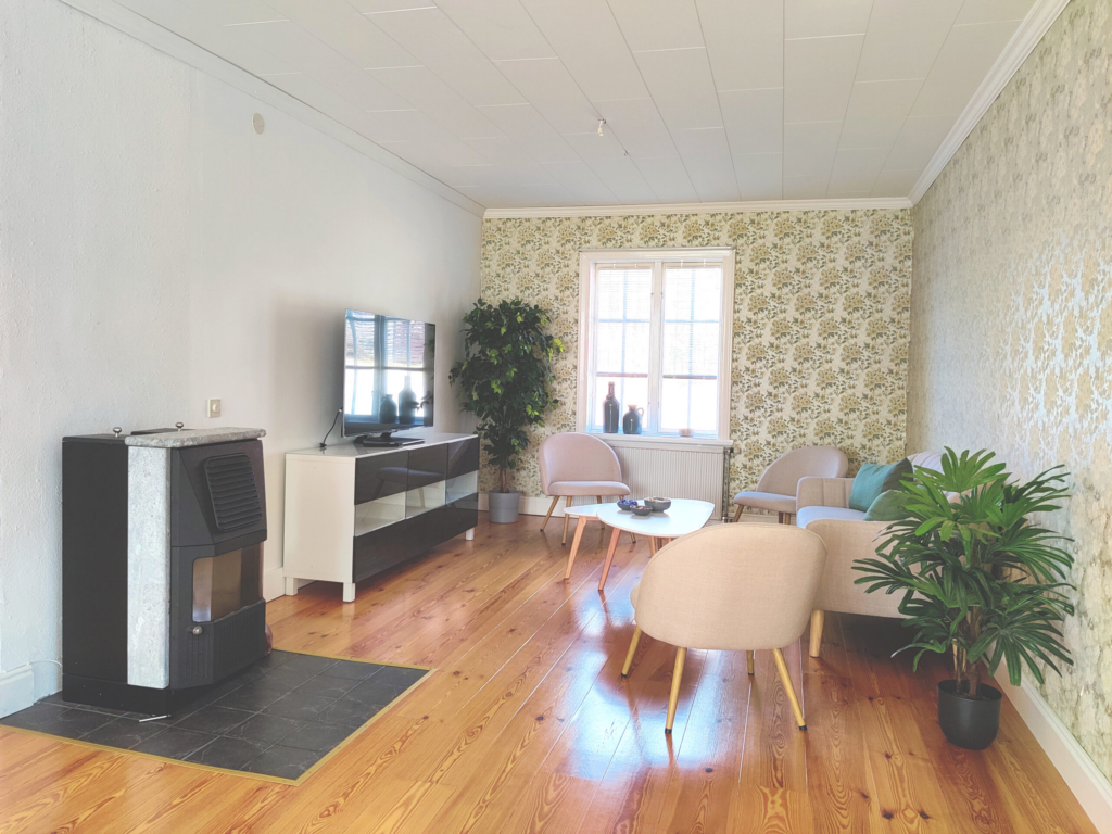 Gezellige zithoek in Hus Björken met comfortabele fauteuils en open haard voor een ontspannen sfeer.