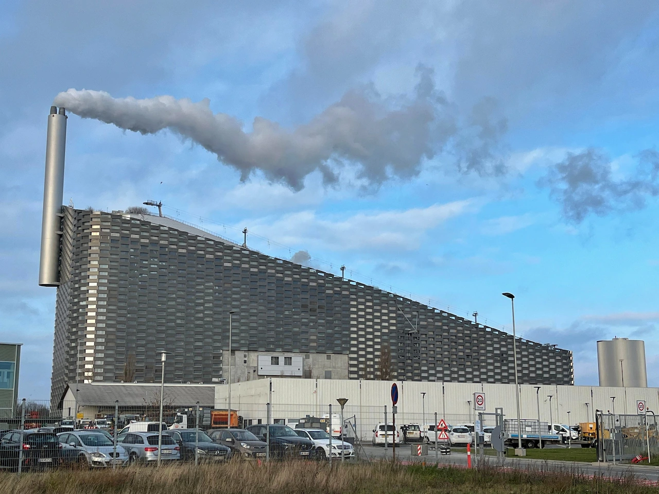 De moderne afvalenergiecentrale CopenHill in Kopenhagen met de skibaan en het wandelpad op het dak.