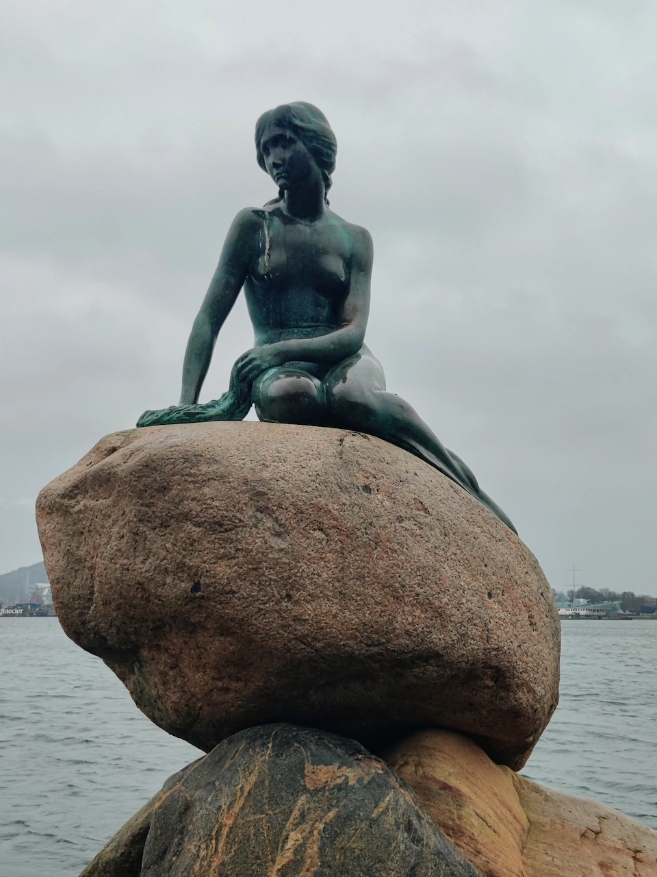 Het bronzen standbeeld van de Kleine Zeemeermin op een rots in de haven van Kopenhagen.