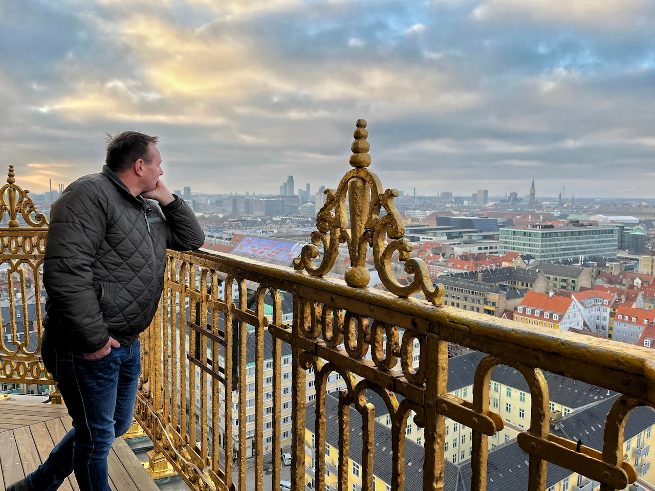 Erik genietend van het uitzicht over de stad Kopenhagen bovenop de toren van de Verlosserskerk.