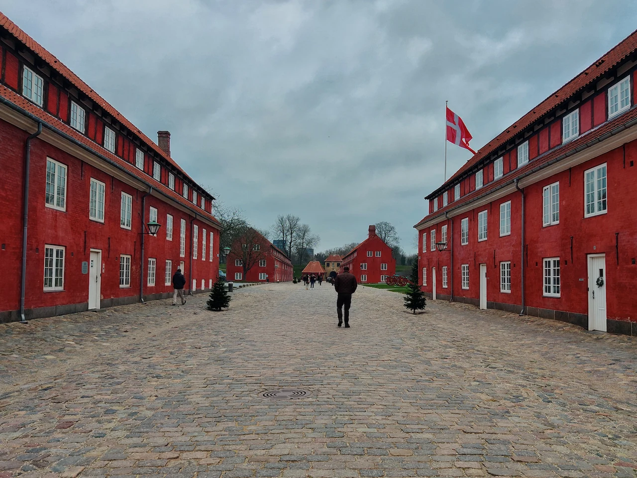 Erik wandelt tussen de historische rode kazernegebouwen van de vesting Kastellet in Kopenhagen.