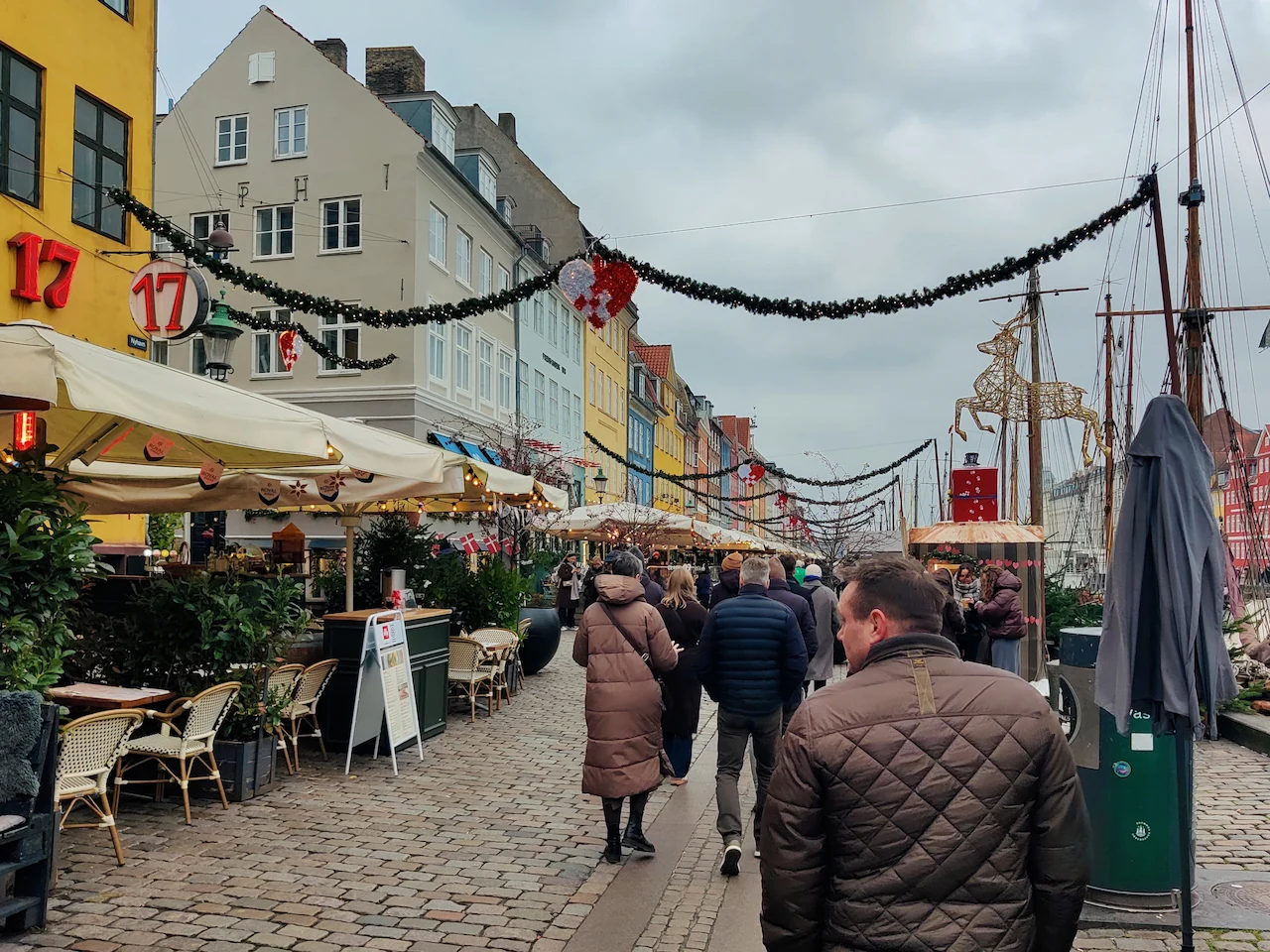 Erik wandelt over de drukke kade van Nyhavn in Kopenhagen langs de gezellige terrasjes en kerstkraampjes.