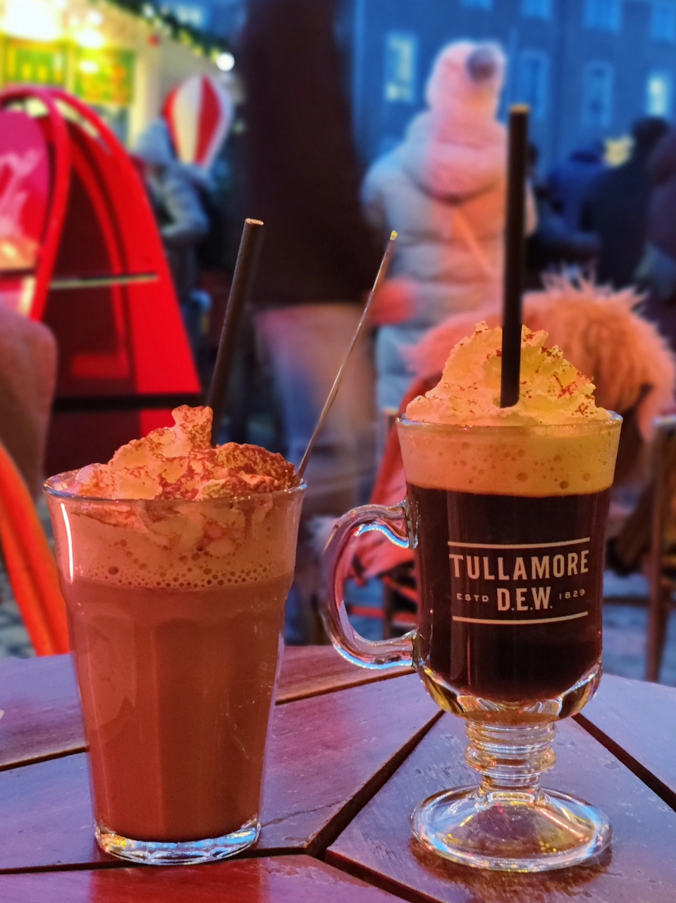 Een glas warme chocolademelk met een flinke toef slagroom en een Irish coffee op een terras in Kopenhagen.