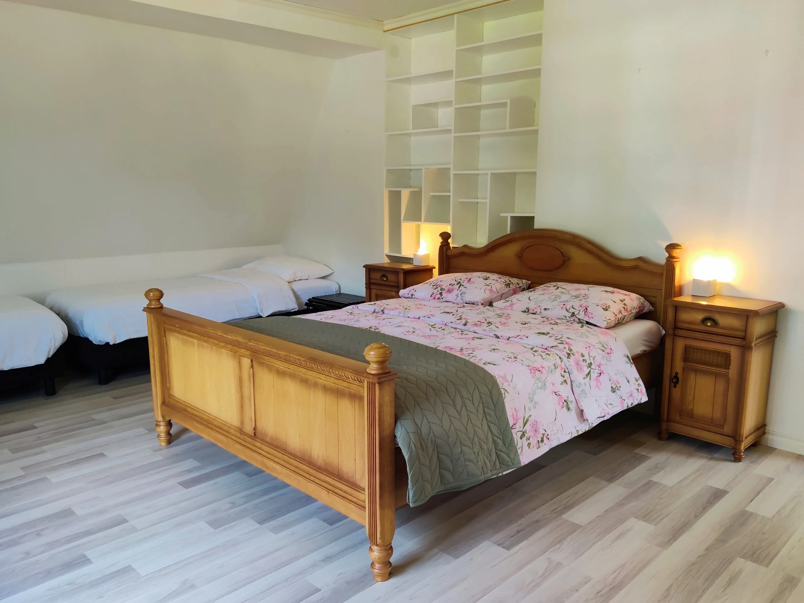 Lichte vierpersoons slaapkamer met houten tweepersoonsbed en twee boxsprings in Hus Björken