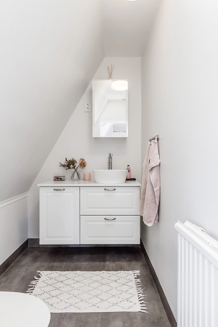 Modern toilet met badmeubel, waskom en spiegelkast op de bovenverdieping van Hus Björken