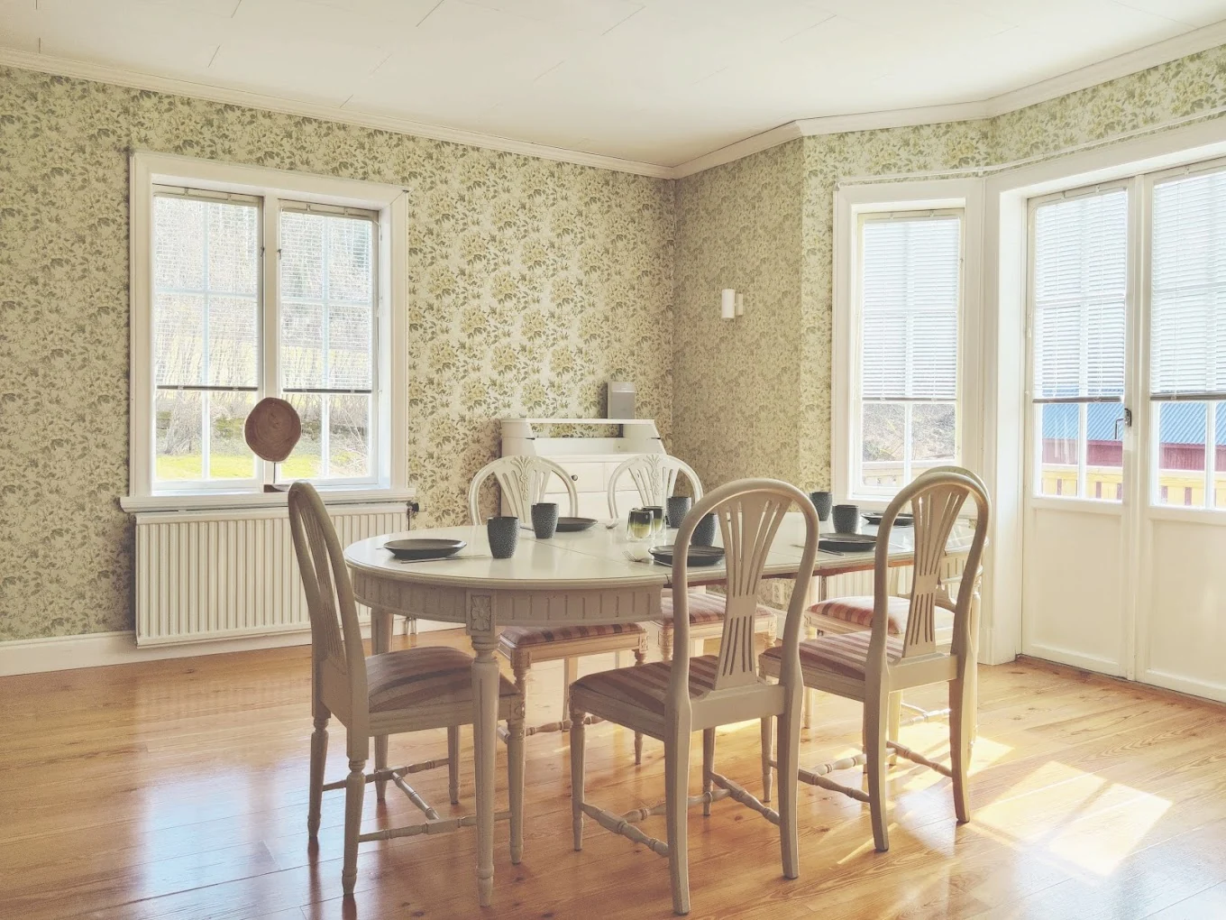 Lichte eetkamer van Hus Björken met eethoek voor zes personen en openslaande deuren naar de veranda