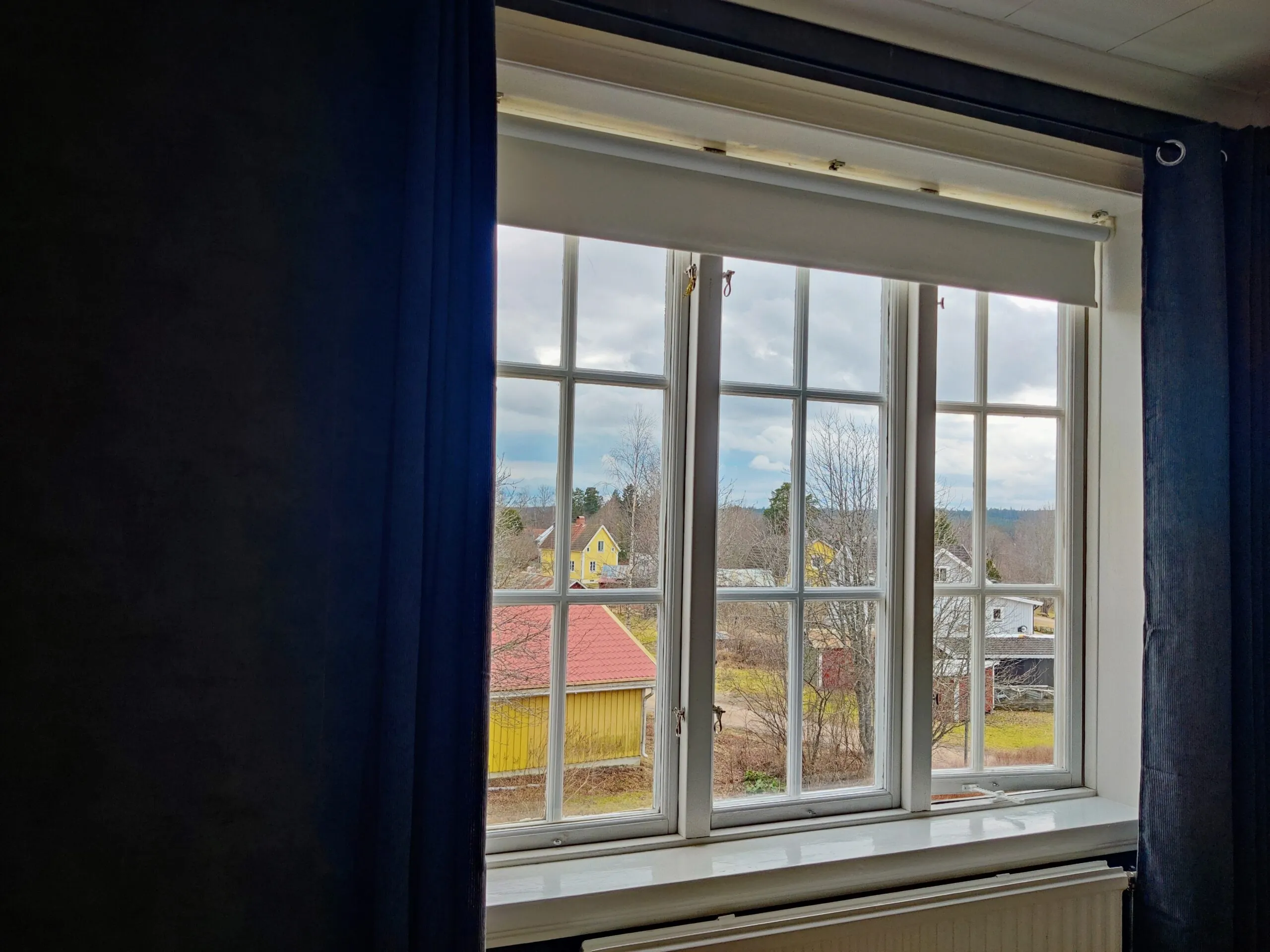 Uitzicht op de diepe achtertuin en de Zweedse natuur vanuit het raam op de bovenverdieping