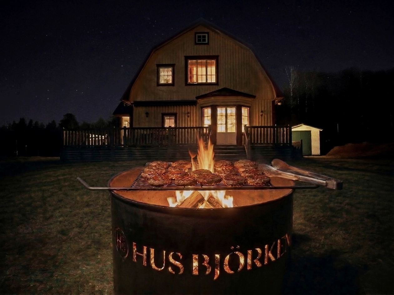 Gezellige vuurplaats met hamburgers op het rooster in de tuin van vakantiehuis Hus Björken in Zweden.